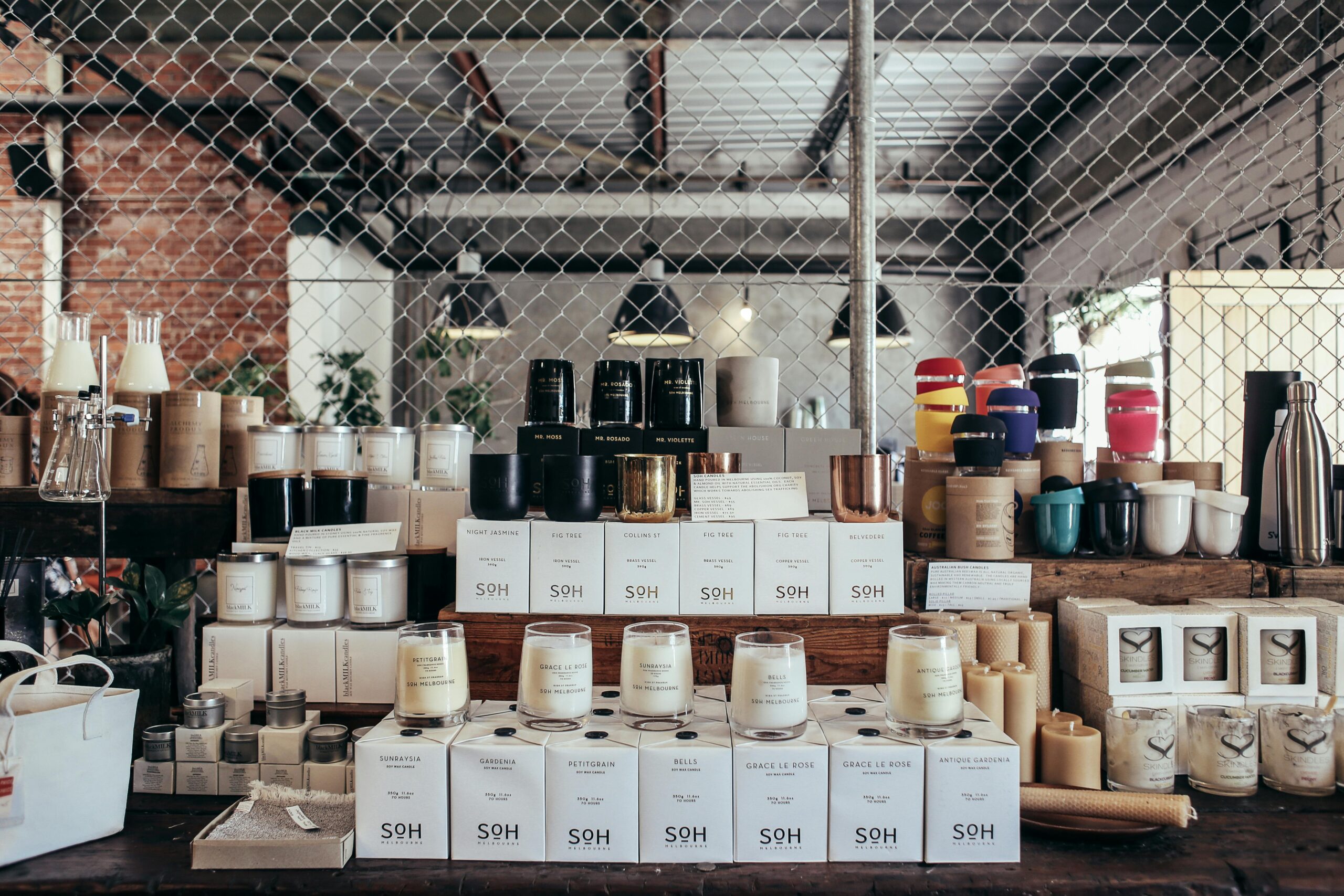 A curated display of handmade candles and home goods on a rustic counter, perfect for cozy interiors.